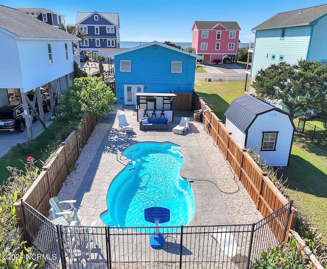 view of swimming pool with a shed, a patio area, and a lawn