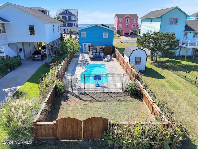 view of swimming pool featuring a storage unit and a yard