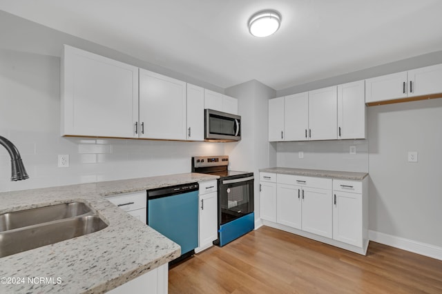 kitchen with light stone countertops, light wood-type flooring, white cabinets, a sink, and stainless steel appliances