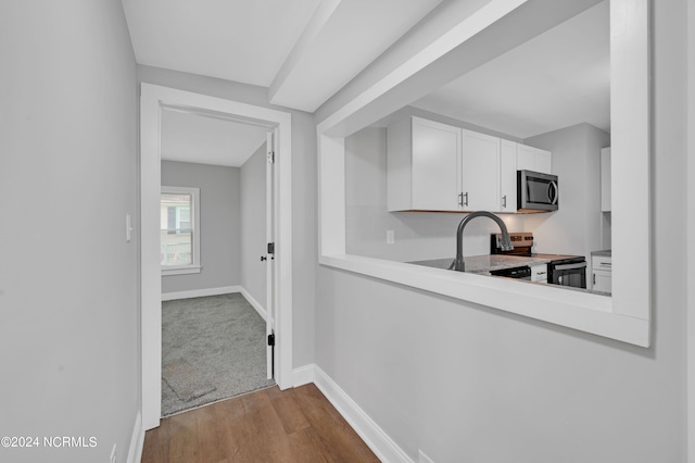 kitchen with light hardwood / wood-style floors, white cabinets, appliances with stainless steel finishes, and sink