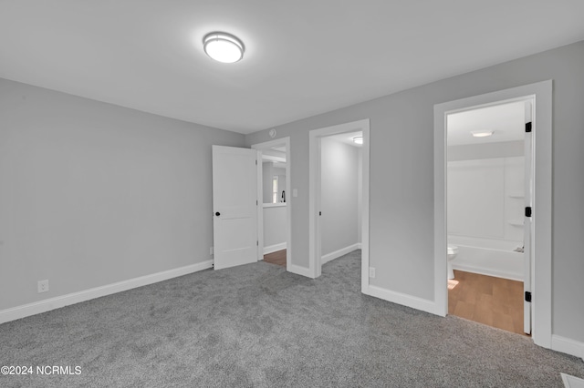 unfurnished bedroom with baseboards, carpet, and ensuite bathroom