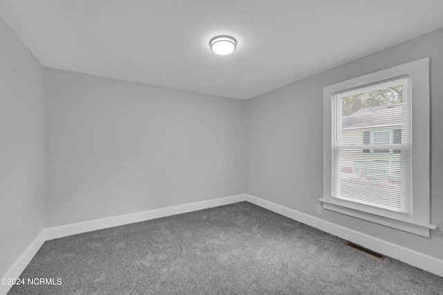 empty room with visible vents, carpet, and baseboards