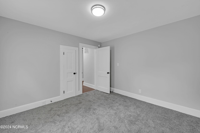 unfurnished bedroom featuring baseboards and carpet