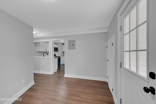 foyer featuring baseboards, wood finished floors, and electric panel