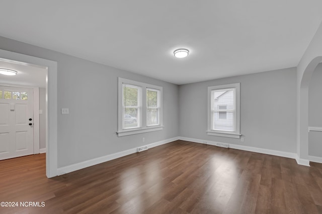 spare room with plenty of natural light, dark wood-type flooring, and visible vents