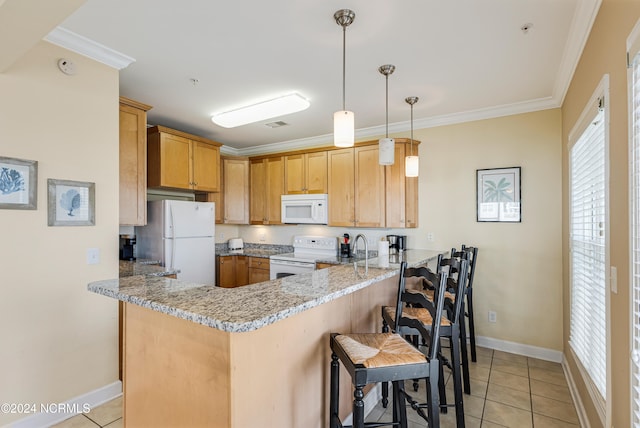 kitchen featuring kitchen peninsula, crown molding, a kitchen bar, light stone counters, and white appliances