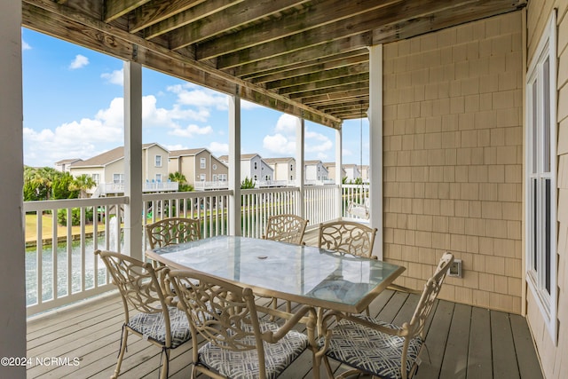 sunroom featuring a water view