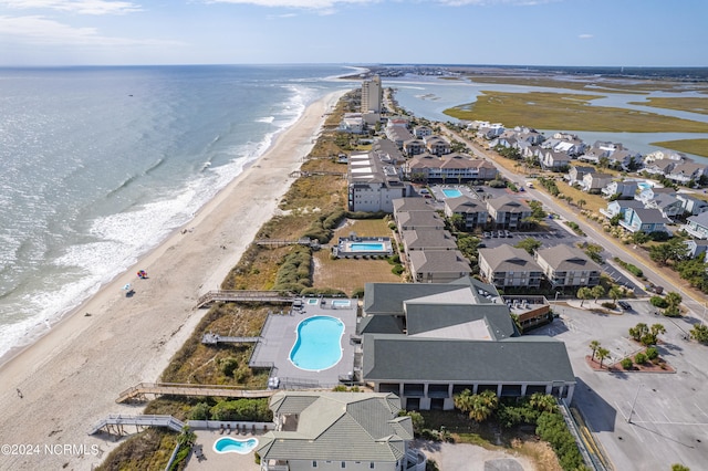 birds eye view of property with a water view and a beach view