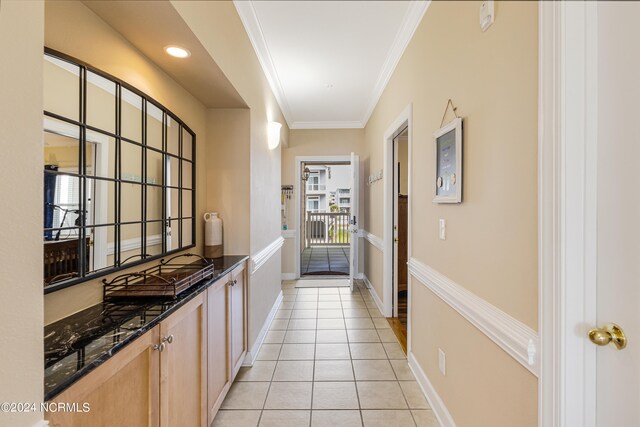 interior space featuring crown molding and light tile patterned floors