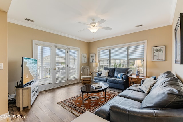 living room with dark hardwood / wood-style flooring, crown molding, and a wealth of natural light