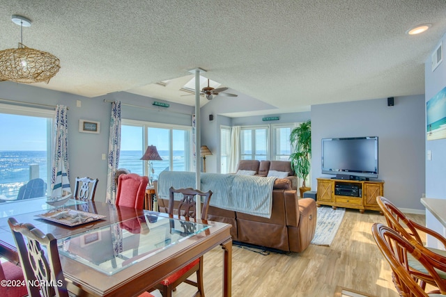 dining room with light hardwood / wood-style flooring, a textured ceiling, and ceiling fan