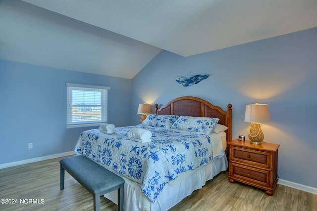 bedroom featuring lofted ceiling and hardwood / wood-style floors