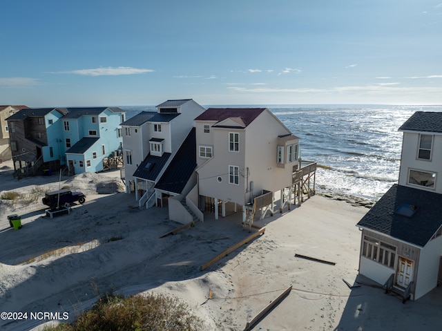 birds eye view of property featuring a water view and a beach view