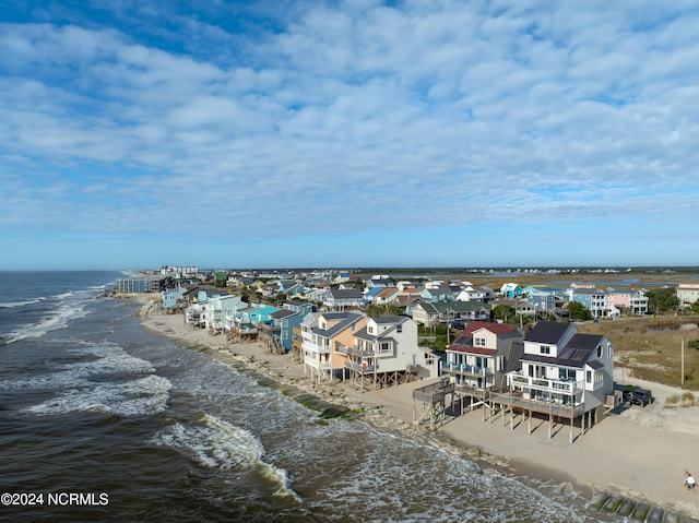 birds eye view of property featuring a water view and a beach view