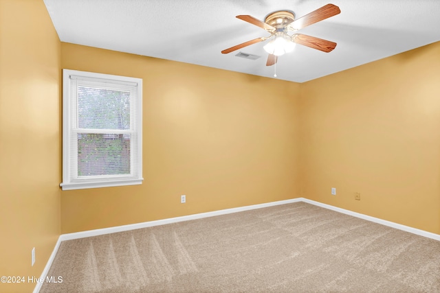 carpeted spare room with ceiling fan