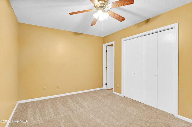 unfurnished bedroom featuring ceiling fan, light carpet, and a closet