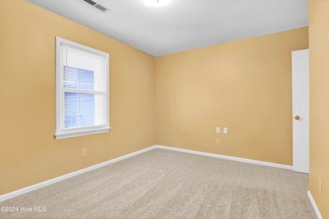 carpeted spare room featuring a textured ceiling