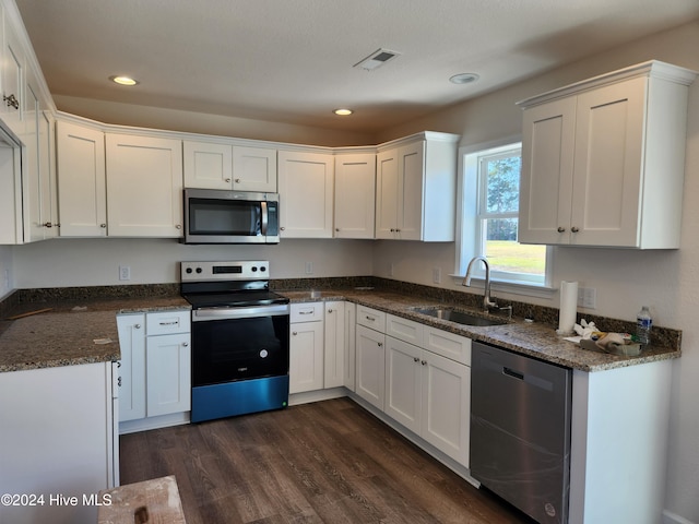 kitchen featuring white cabinets, appliances with stainless steel finishes, dark hardwood / wood-style flooring, and sink