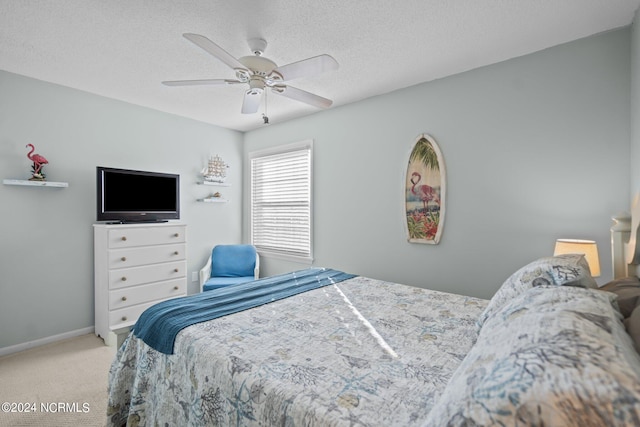 bedroom featuring ceiling fan, a textured ceiling, and light carpet