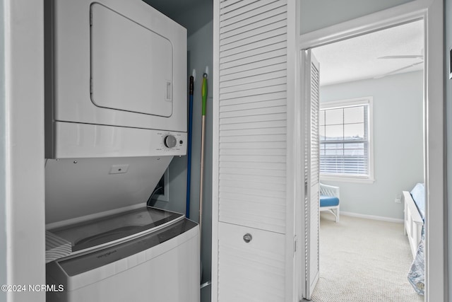 laundry area with stacked washer and clothes dryer, ceiling fan, and carpet floors