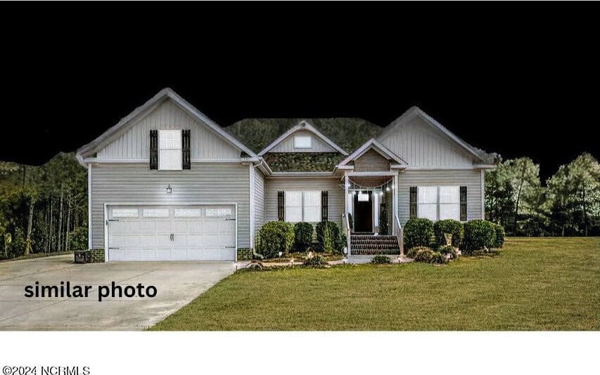 view of front of home featuring a front yard and a garage