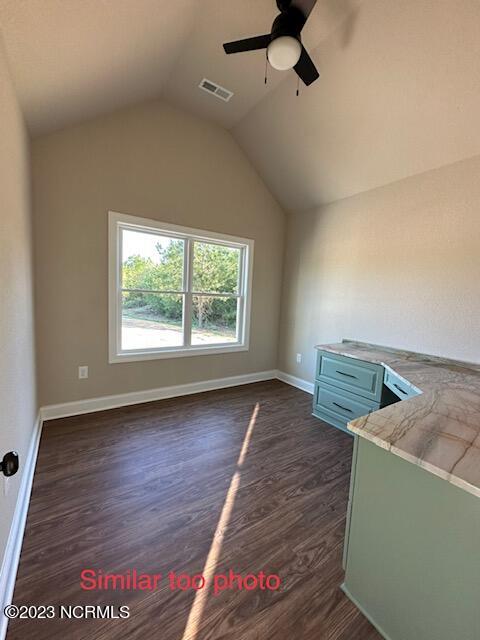 bonus room featuring dark hardwood / wood-style floors, vaulted ceiling, and ceiling fan