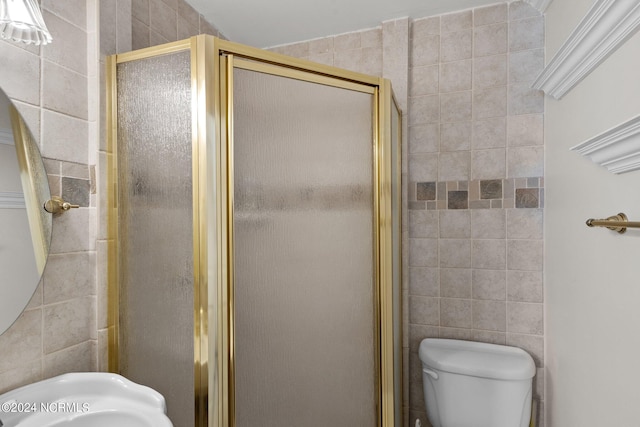 full bath featuring tile walls, a shower stall, and toilet
