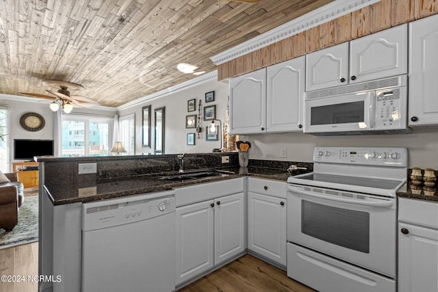 kitchen featuring white appliances, a sink, a peninsula, white cabinetry, and ornamental molding