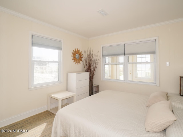 bedroom featuring crown molding and light hardwood / wood-style floors