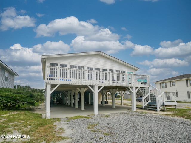 raised beach house featuring a wooden deck