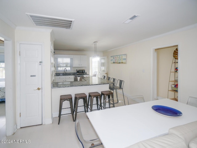 dining room with crown molding and sink