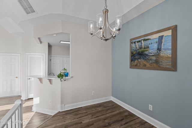 unfurnished dining area with an inviting chandelier and dark wood-type flooring