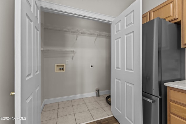 clothes washing area featuring washer hookup, electric dryer hookup, and light tile patterned flooring