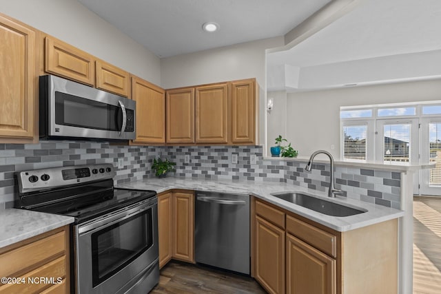 kitchen featuring sink, stainless steel appliances, tasteful backsplash, and dark wood-type flooring