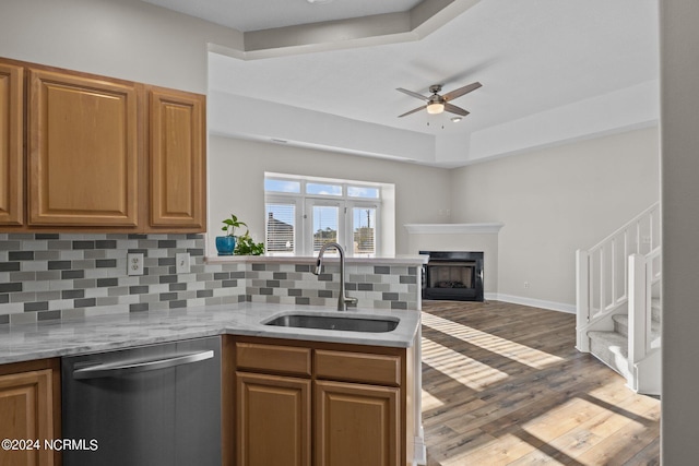 kitchen with ceiling fan, dishwasher, sink, dark hardwood / wood-style floors, and decorative backsplash