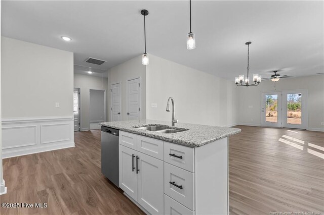 kitchen with dishwasher, ceiling fan with notable chandelier, sink, decorative light fixtures, and white cabinetry