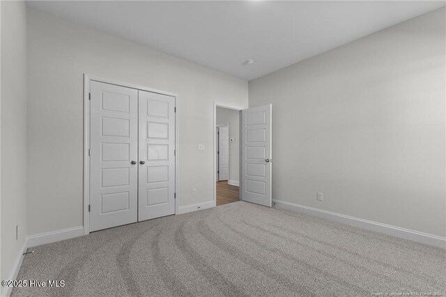 unfurnished bedroom featuring carpet flooring and a closet