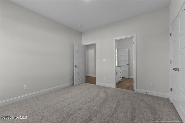 unfurnished bedroom with connected bathroom and carpet