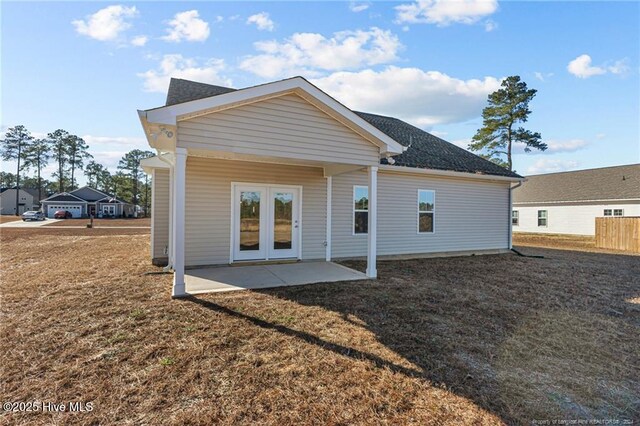 back of house featuring a lawn, a patio area, and french doors