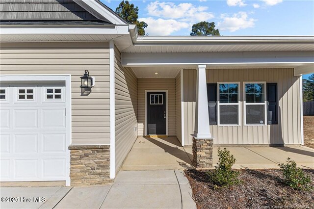 property entrance featuring a porch and a garage