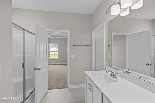 bathroom with tile patterned floors, a shower stall, vanity, and baseboards