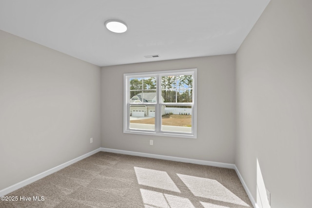 carpeted spare room with visible vents and baseboards