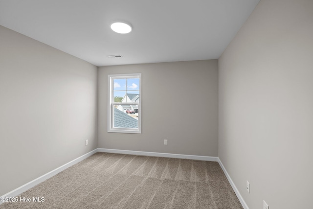 carpeted empty room with visible vents and baseboards