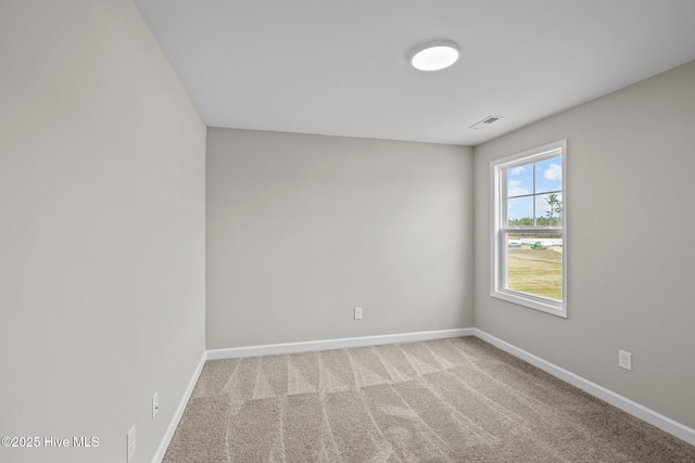 spare room featuring carpet flooring, visible vents, and baseboards