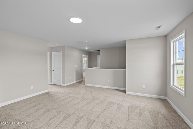 carpeted empty room with visible vents and baseboards