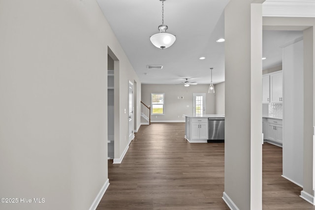 hall featuring dark wood-type flooring, visible vents, stairway, and baseboards