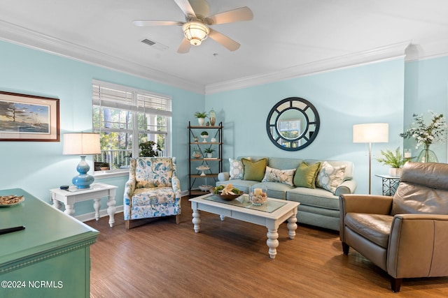 living room with wood-type flooring, ornamental molding, and ceiling fan