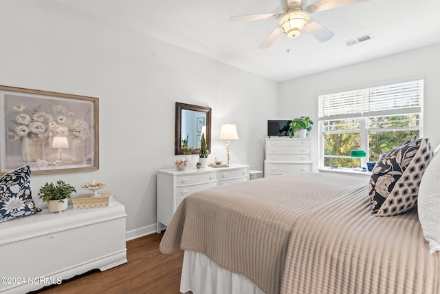 bedroom with dark hardwood / wood-style flooring and ceiling fan