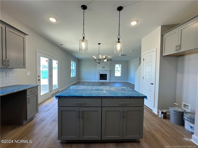 kitchen with gray cabinetry, stone counters, and dark hardwood / wood-style floors