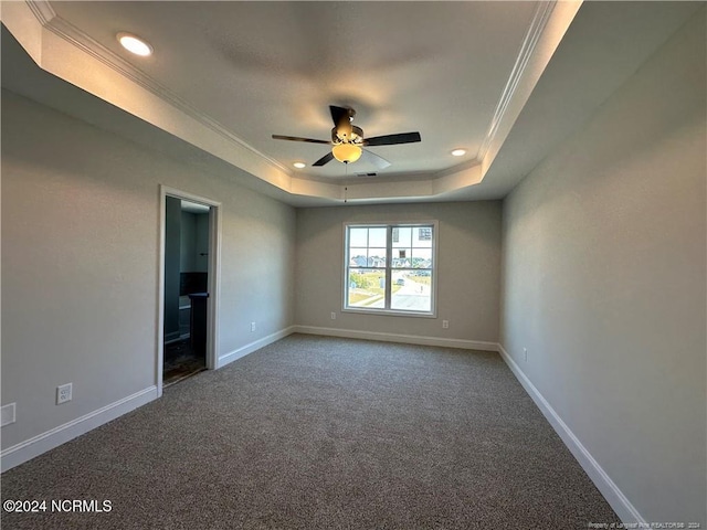 carpeted spare room with crown molding, a raised ceiling, and ceiling fan